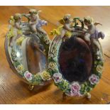A pair of Sitzendorf porcelain oval table mirrors decorated with roses and leaves in bold relief,
