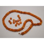 A row of pressed amber beads, and a quantity of loose beads,
