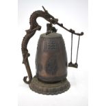 A Korean, or other Asian, bell with a dragon handle and circular, foliate base, 28.