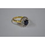 An oval dark blue sapphire and diamond cluster ring,