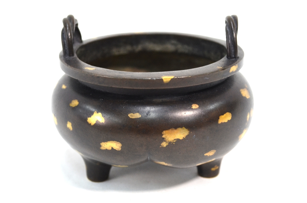 A Chinese bronze incense burner of tripod and circular form with rope-twist handles,