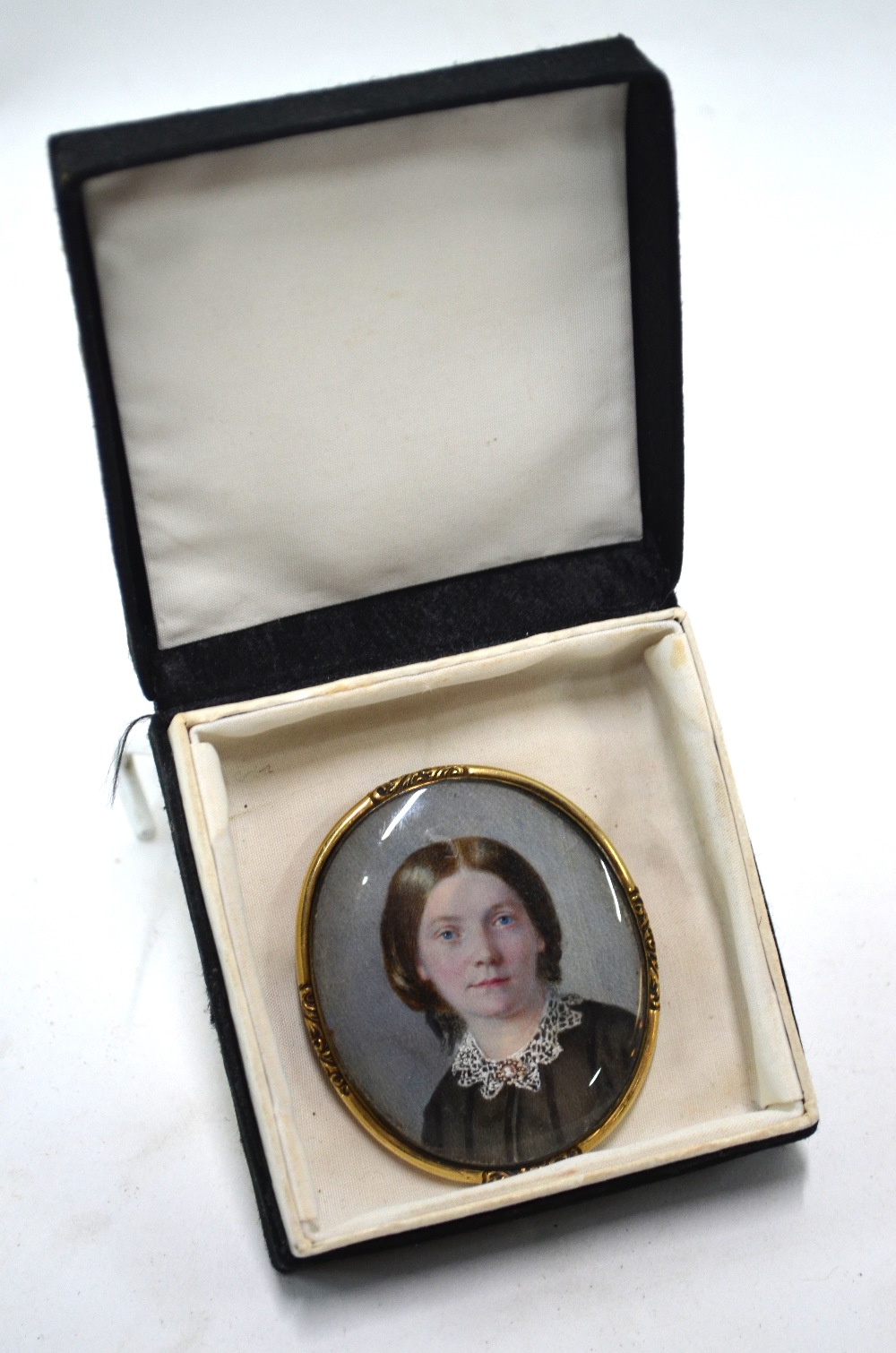 A Victorian oval portrait miniature on ivory of a young lady in mourning clothes; unsigned,