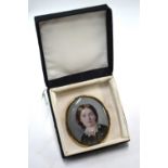 A Victorian oval portrait miniature on ivory of a young lady in mourning clothes; unsigned,