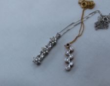 A diamond set pendant on a yellow metal chain,