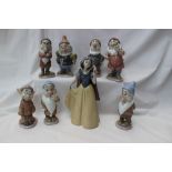 A Lladro figure of Snow White together with the Seven Dwarves figures,