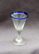 An 18th century wine glass with a blue glass rim and a spreading foot,