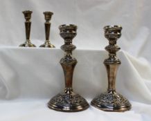 A pair of Elizabeth II silver candlesticks, embossed with scrolls and leaves, Birmingham, 1962, 19.