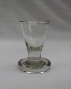 A 19th century shot glass with a tapering flared bowl on a thick circular base,