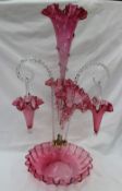 A Victorian cranberry glass epergne, with a central trumpet, two other trumpets,