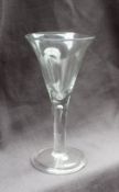 A large 18th century wine glass with a trumpet shaped bowl on a tear drop drawn stem and spreading