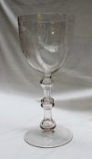 A 19th century over sized wine glass with a rose engraved bowl,