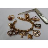 A yellow metal twisted link bracelet marked 750, together with numerous yellow metal charms,