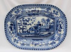 A 19th century blue and white pottery meat plate, decorated to the centre with a fortified town,