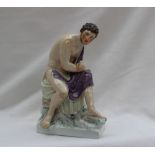 A Berlin porcelain figure of a seated male, draped in cloth,