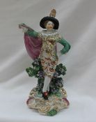 An 18th century Derby pottery figure of a gentleman in a pink cape with flowers and leaves on a