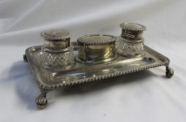 An Edwardian silver desk standish, of rectangular form with a gadrooned edge, on ball and claw feet,