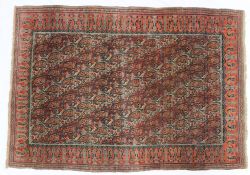 A Persian Qum type rug with a red ground with multiple boteh in a diagonal pattern,