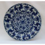 A Delft pottery plate decorated to the centre and rim with flowers,