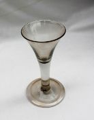 An 18th century wine glass with a tapering trumpet shaped bowl on a plain drawn stem,