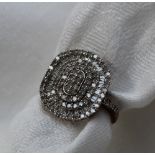 A diamond dress ring of oval form set with round brilliant and baguette cut diamonds to a 9ct