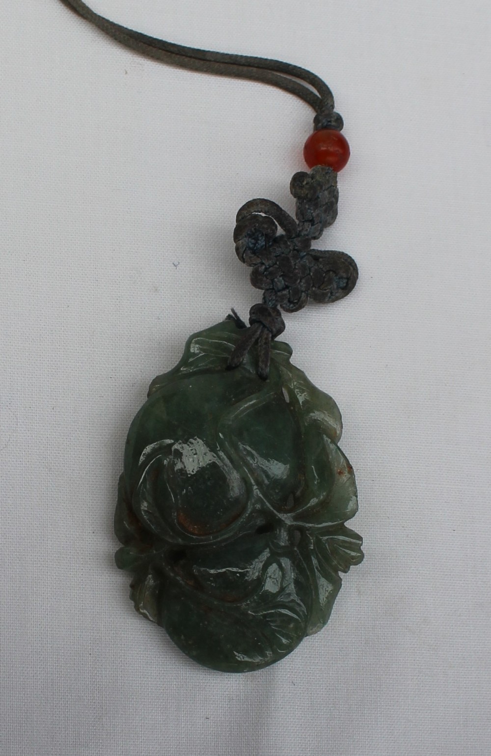 A carved jade pendant in the form of fruit and leaves on a cord necklace 55mm x 35mm - Image 2 of 3