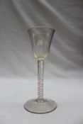 An 18th century wine glass with a tapering bowl above a double helix air twist stem on a spreading