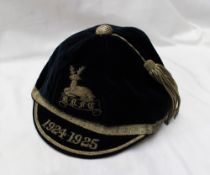 A blue velvet cap with a silver thread tassel, embroidered with a stag and the initials B-R-F-C,