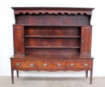 An 18th century oak and mahogany dresser, the rack with a moulded cornice,