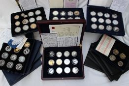 A large collection of silver coins and coin sets including Charles Darwin,
