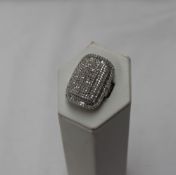 A diamond dress ring of rounded rectangular form set with round brilliant and baguette cut diamonds