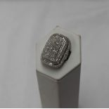 A diamond dress ring of rounded rectangular form set with round brilliant and baguette cut diamonds