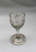 An 18th century dram glass, with rounded bowl embellished with etched vine and bird decoration,