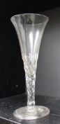 An 18th century oversized wine glass with a trumpet shaped bowl faceted stem with internal tear