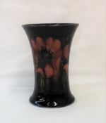 A Moorcroft pottery vase of flared form decorated with flambe anenome to a blue ground,