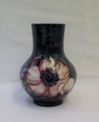 A Moorcroft pottery baluster vase decorated in the anemone pattern to a blue ground,