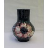 A Moorcroft pottery baluster vase decorated in the anemone pattern to a blue ground,