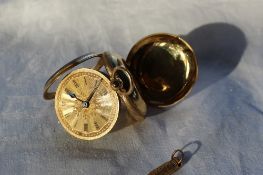 An 18ct yellow gold key wound open faced fob watch with Roman numerals and a floral decorated gilt