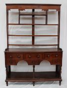 An 18th century South Wales oak dresser, the rack with a moulded cornice above open shelves,