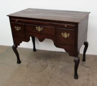 An 18th century and later oak lowboy, the planked rectangular top above a brushing slide,