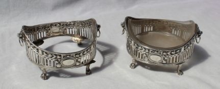 A pair of Edward VII silver bottle coaster with glass liners decorated with lions heads on lions