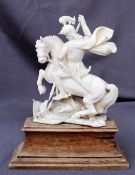 A 19th century carved ivory figure of St George and the Dragon mounted on a wooden plinth,