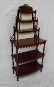 A Victorian rosewood whatnot, with six shelves supported on barley twist uprights and turned feet,