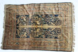 A silk rug with a central panel on a blue ground, depicting a central tree trunk with monkeys,