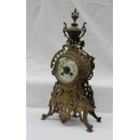 A 19th century bronze mantle clock, with an urn finial, pierced decoration and mask on four legs,