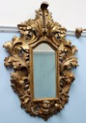 A 19th century gilt gesso wall mirror decorated with scrolling leaves and figural mask,