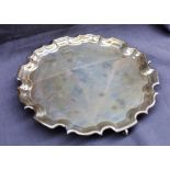 An Elizabeth II silver salver with a shaped edge on three scrolling feet, Sheffield, 1997,