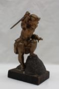A Dutch Bronze model of a boy musketeer holding a sword aloft,