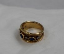 A Sapphire and diamond ring set with five diamonds and three sapphires to an 18ct yellow gold