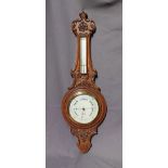 A carved oak aneroid barometer, with a mercury thermometer, the silvered dial inscribed R Bailey,