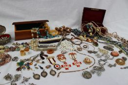 A collection of costume jewellery including brooches, bead necklaces, Red cross badges,